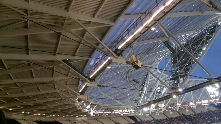 View of rear and front roofs of the London Stadium showing upper, lower and front radial cables connecting to lug plates and tension ring.
